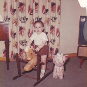 My youngest brother Jack Maupin on his rocking horse, stuffed elephant beside him